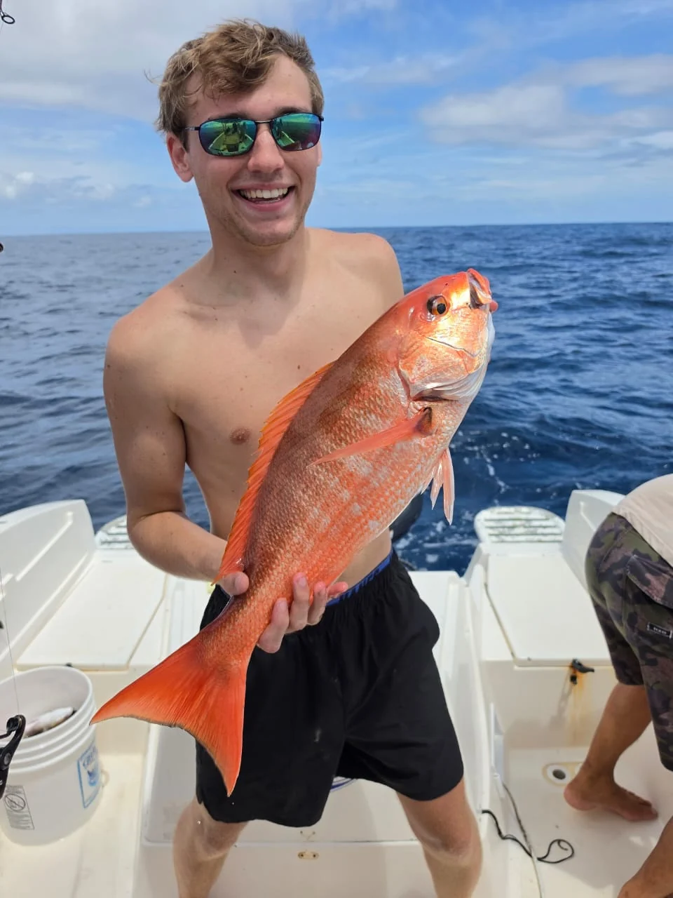 Smiling angler holding a red snapper caught near Jaco Costa Rica during an August 2026 fishing charter