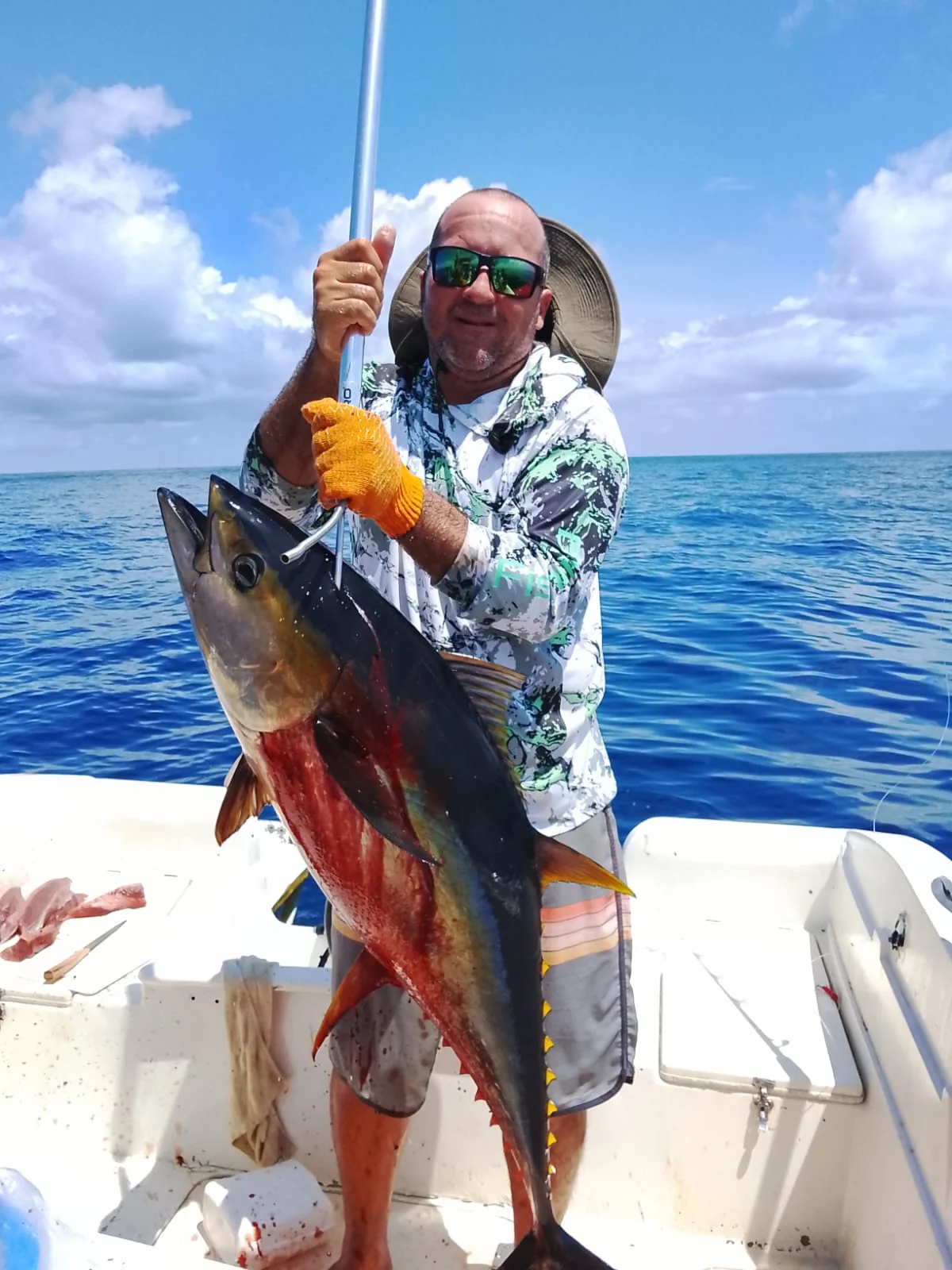 Angler holding a large yellowfin tuna aboard a private offshore charter from Jaco Costa Rica in August 2026