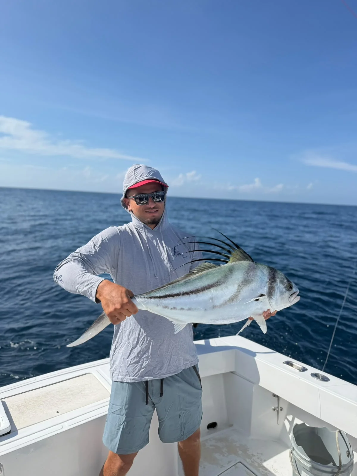 Angler holding a roosterfish caught on an inshore fishing charter near Jaco Costa Rica in August 2026