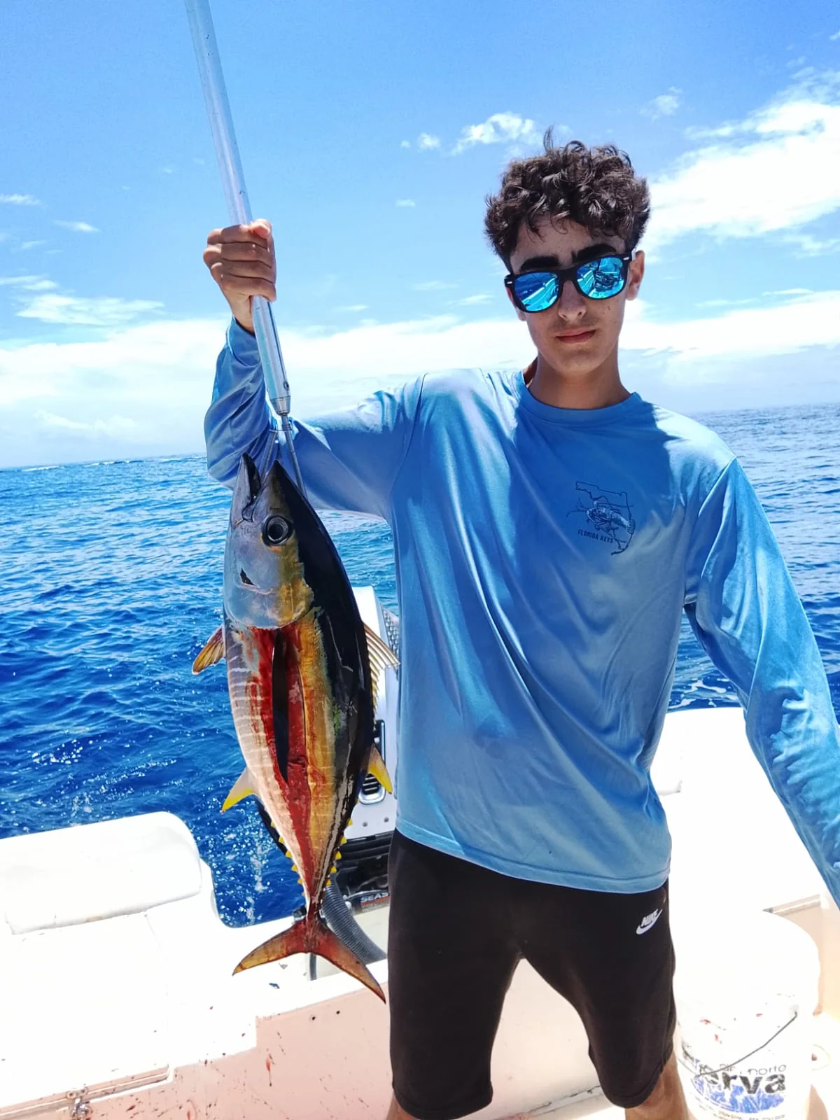 Young angler holding a yellowfin tuna during an offshore fishing trip from Jaco Costa Rica in August 2026