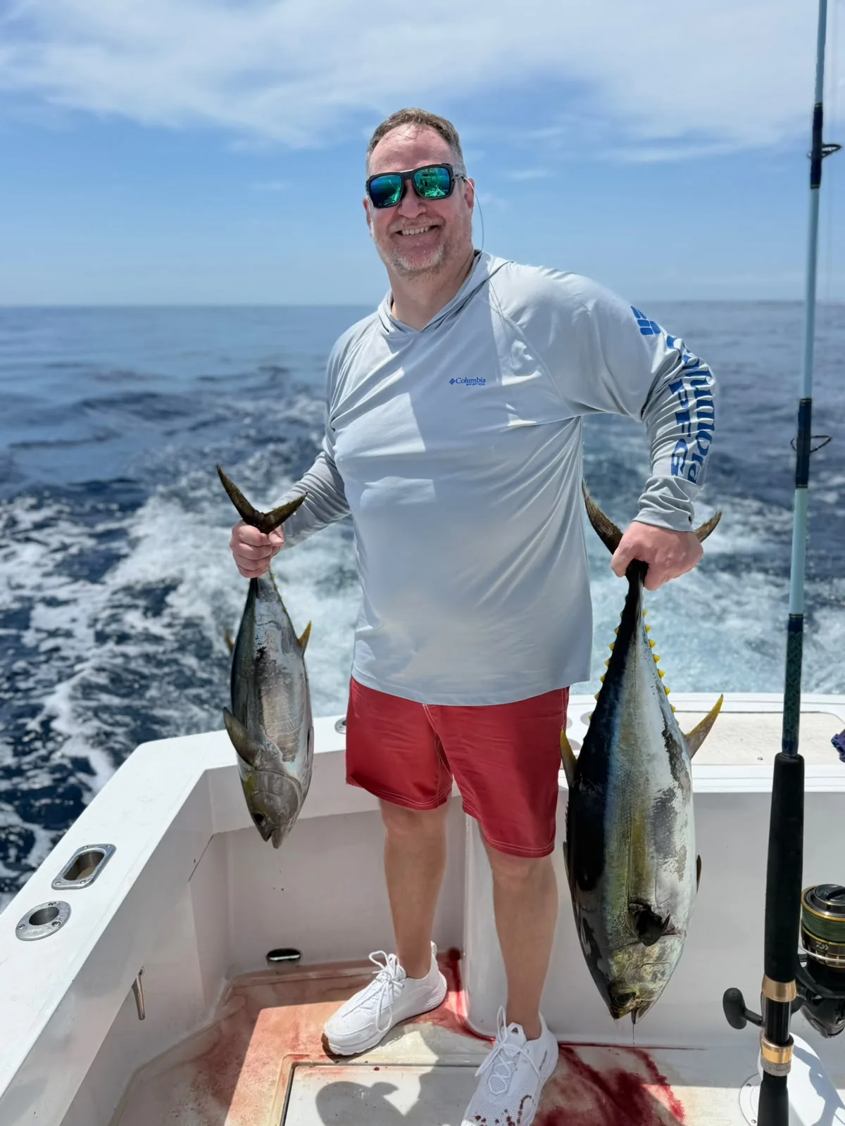 Angler holding two yellowfin tuna on a private offshore fishing charter from Jaco Costa Rica in August 2026