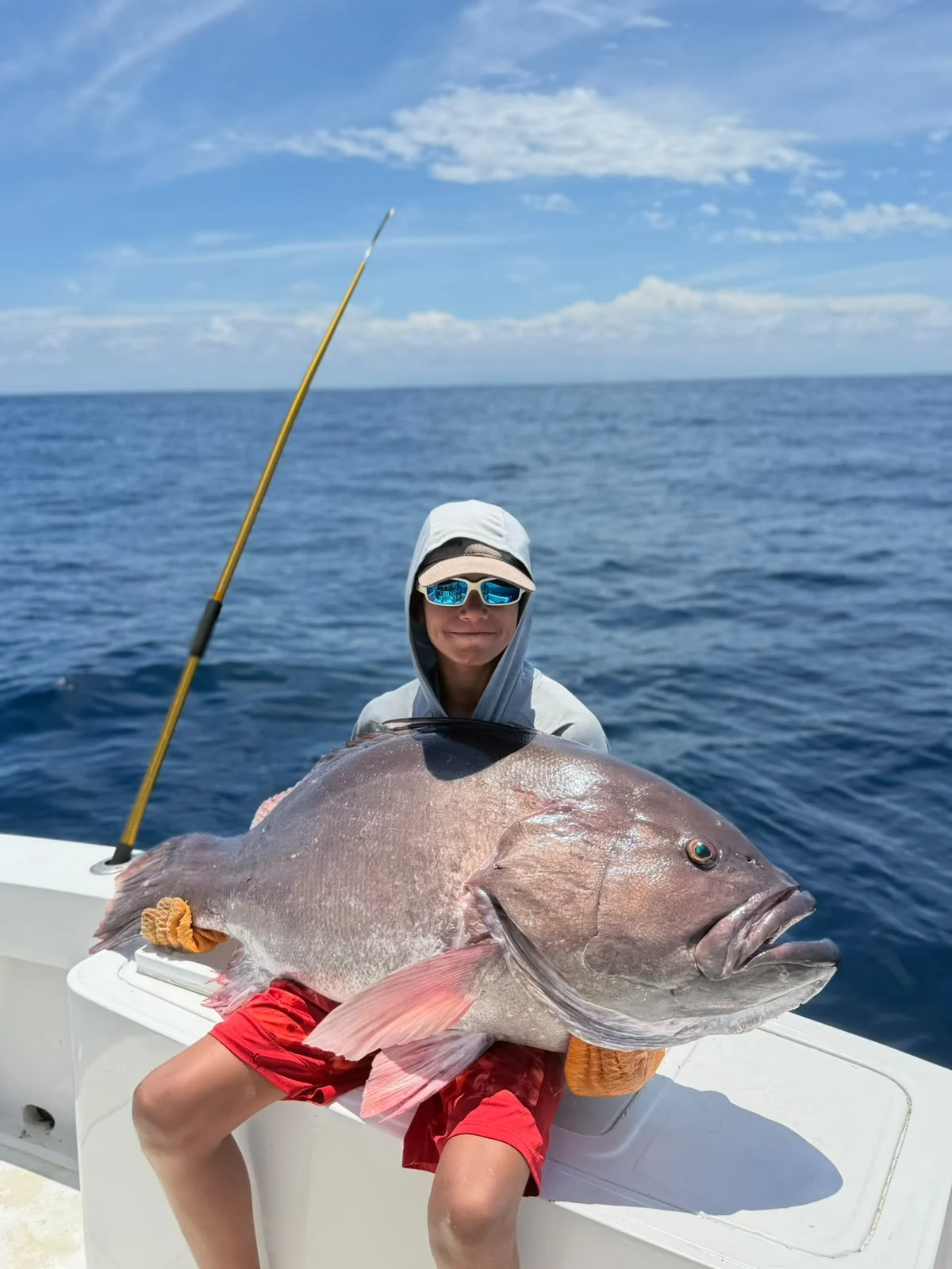 Young angler holding a large grouper caught during a Jaco Costa Rica fishing charter