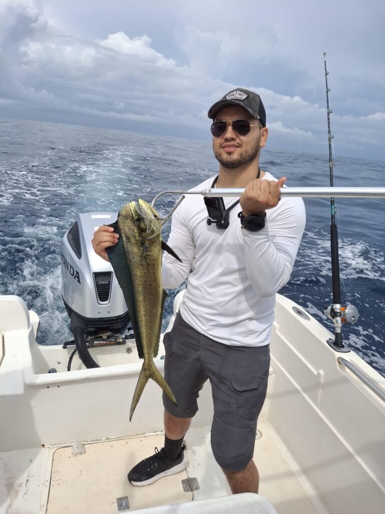 Angler holding a mahi mahi on a Jaco Costa Rica offshore fishing charter in July 2026