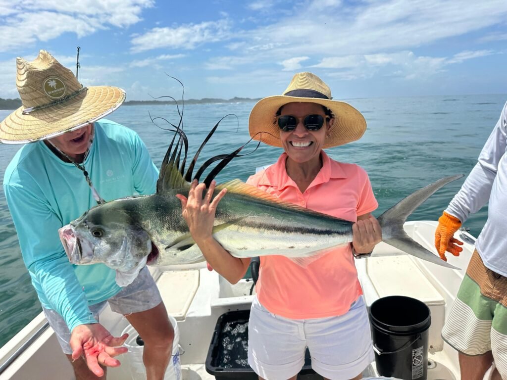 Angler holding a large roosterfish during a July inshore fishing charter near Jaco Costa Rica