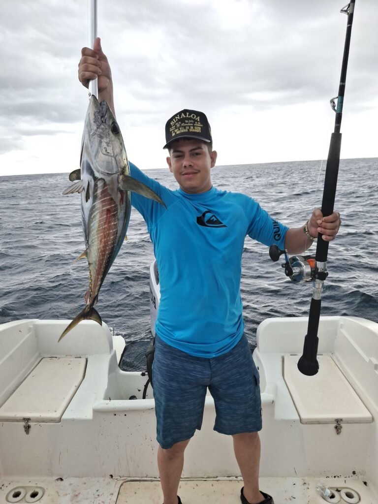 Angler holding a medium-size tuna caught offshore from Jaco Costa Rica in July 2026