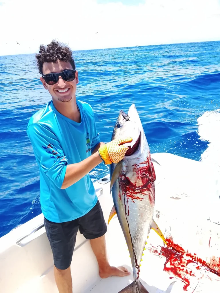 Young angler holding a yellowfin tuna caught offshore from Jaco Costa Rica during August 2026