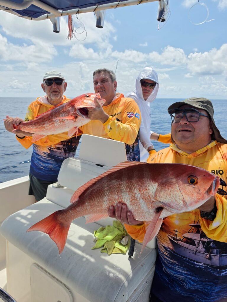 Group of anglers displaying red snapper aboard a fishing boat